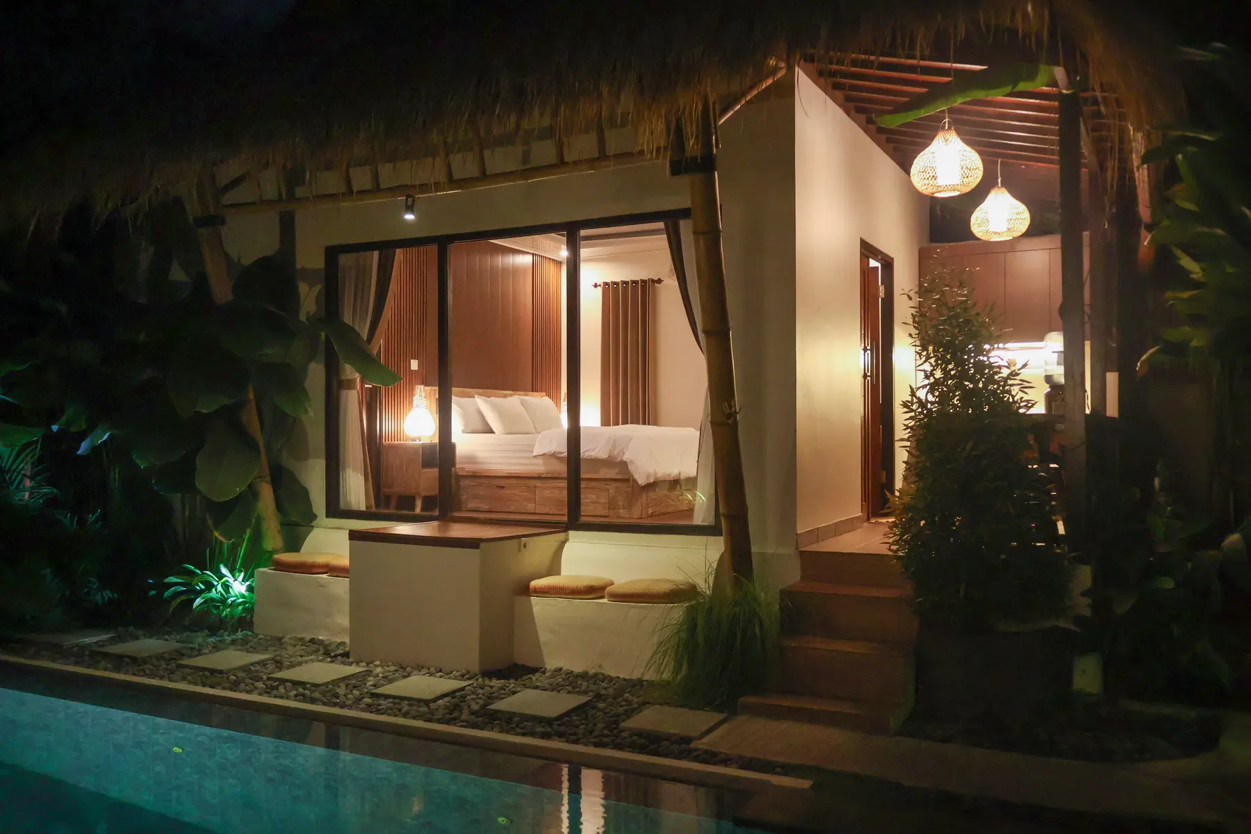 J Ming Villa illuminated beside the pool in the evening